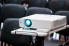 Um projetor 4k em cima de uma mesa em um auditório.