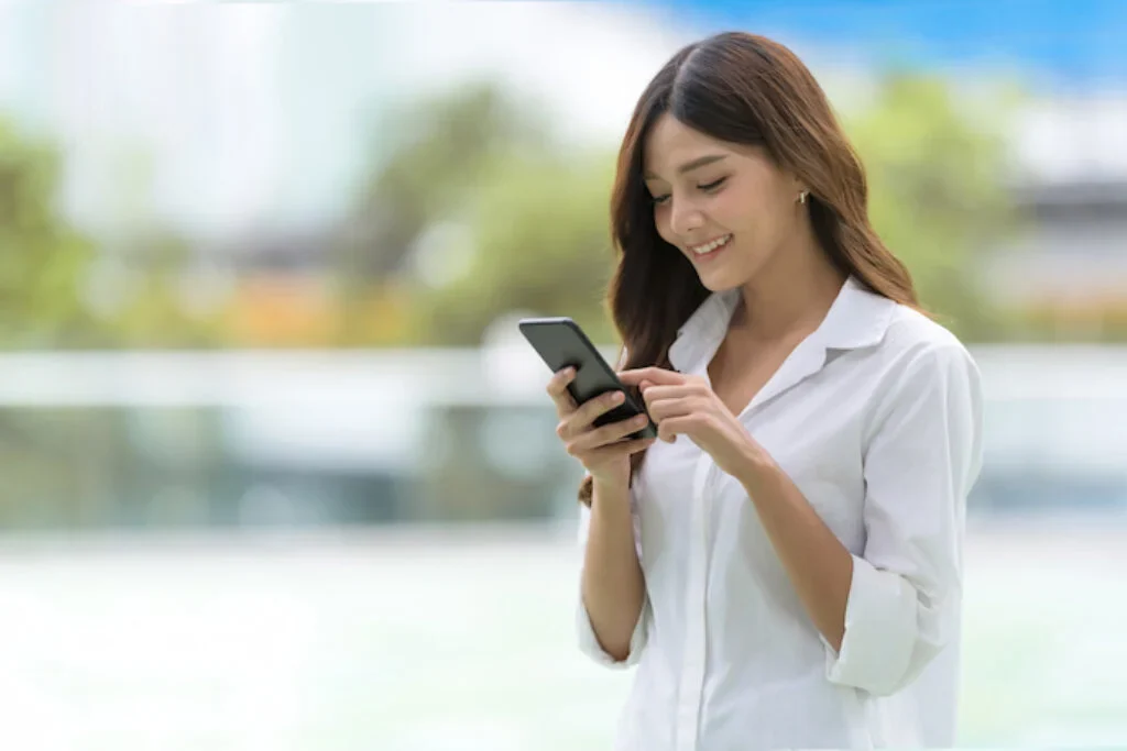 Uma mulher mexendo no celular.