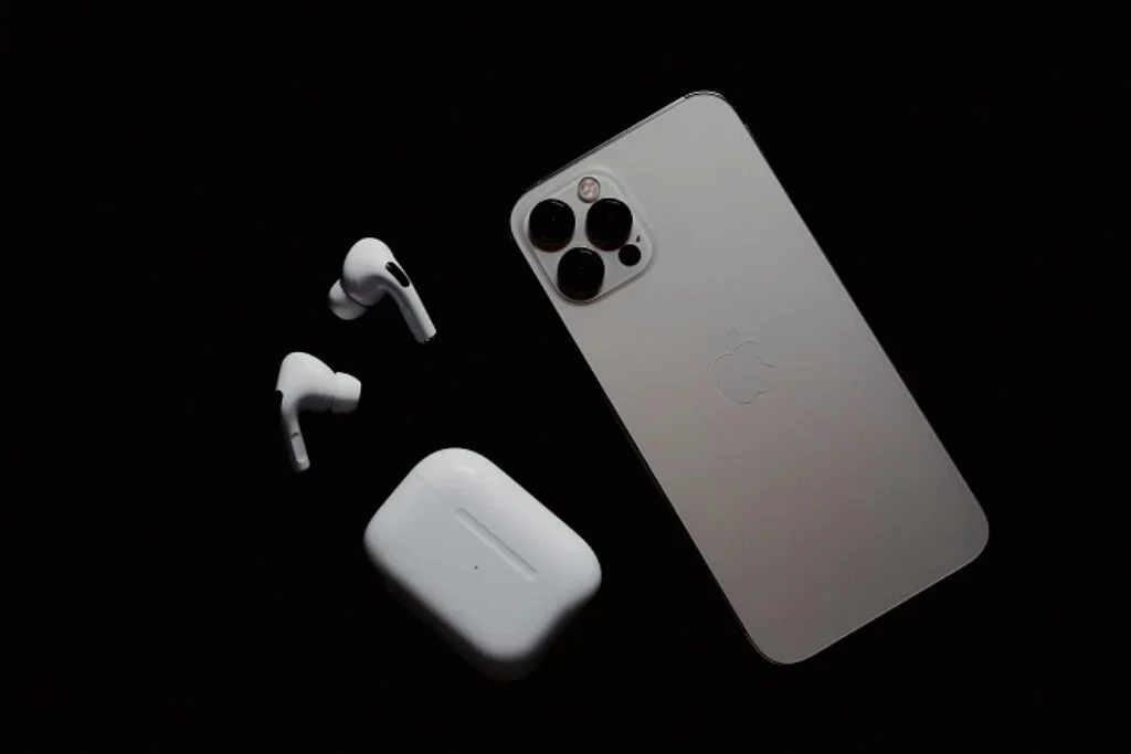 Um celular ao lado de um par de fones.